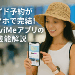 スマートフォンでNaviMeアプリを操作する女性の写真と白文字キャッチコピー「ガイド予約がスマホで完結！NaviMeアプリの新機能解説」